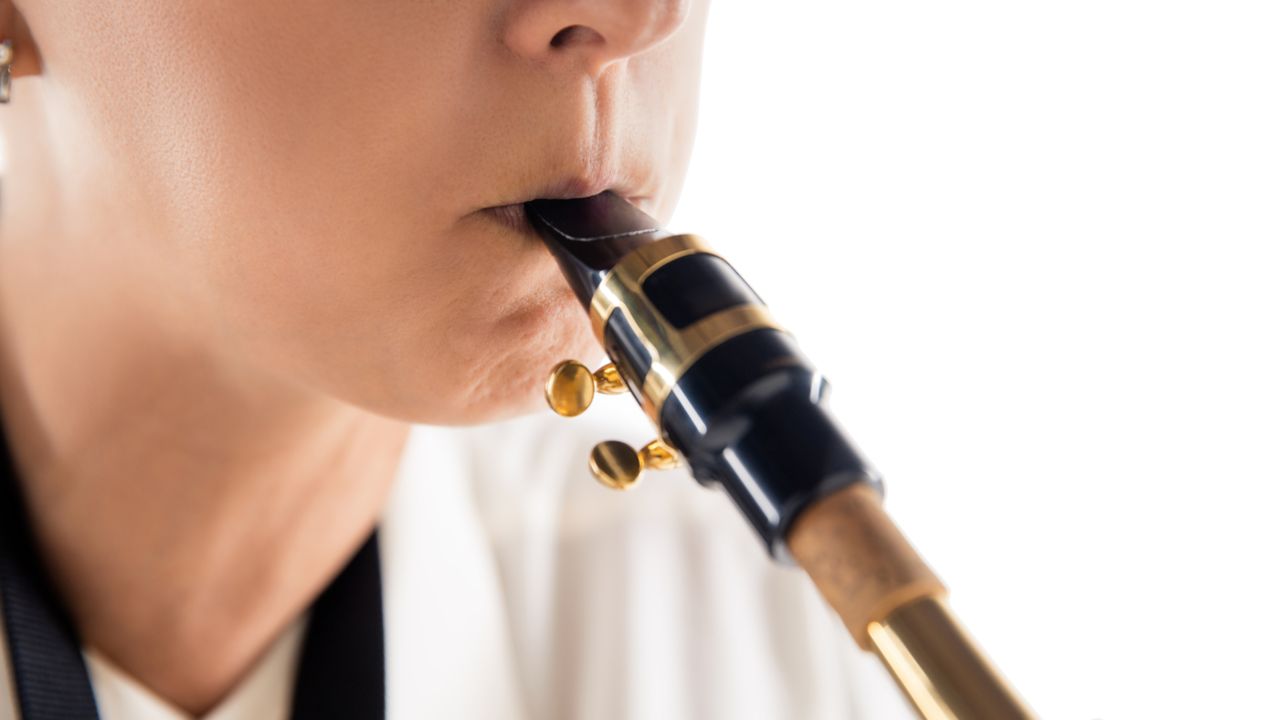Close up woman playing saxophone isolated on white studio background. Inspired musician, details of art occupation, world classic instrument for jazz and blues. Concept of hobby, creativity.